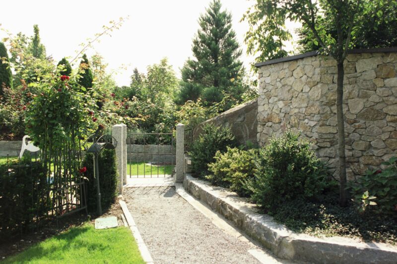 Garten mit zahlreichen Pflanzen im südländischen Flair mit Zyklopenmauerwerk aus Stein