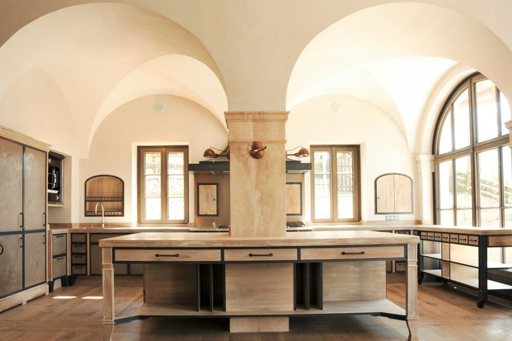 Edles Küchenelement in lichtdurchfluteter Designerküche im Landhausstil mit Kreuzgewölbe und integrierter Steinsäule